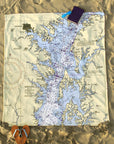 Map of a lake on sand with a heart-shaped object and book