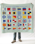 Person holding a blanket with signal flags on a white background