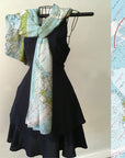 Black dress with a map-patterned scarf draped over a hanger, next to a map of Cape Cod.