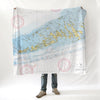 A person standing with a nautical chart blanket draped over their shoulders, displaying detailed map patterns.