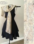 Mannequin wearing a black dress with a Vintage Topographical Map Scarf, next to a close-up of the map design.