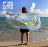 Person holding a map towel on a beach with 'Maritime Tribes' logo.