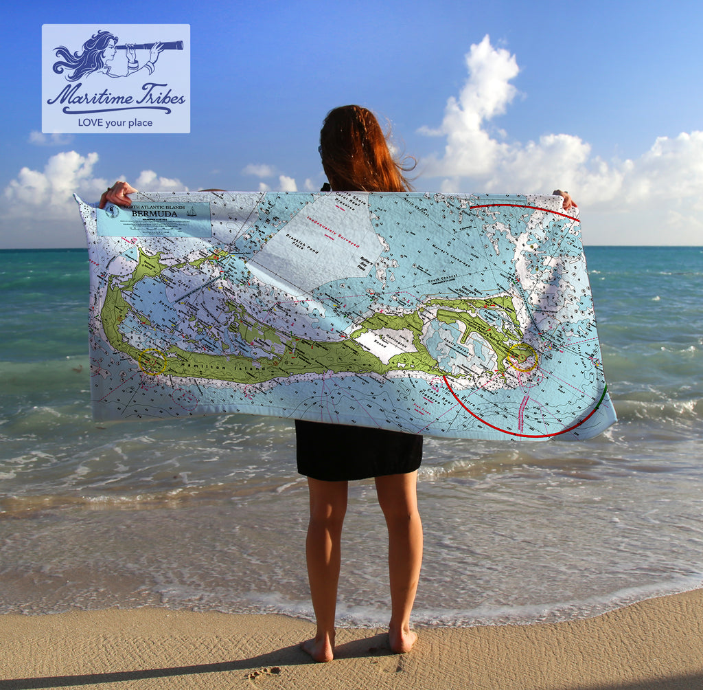 Person holding a map towel on a beach with 'Maritime Tribes' logo.