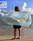 Person holding a map towel on a beach with 'Maritime Tribes' logo.