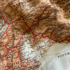 Close-up of a vintage map with red lines and black text on a beige background