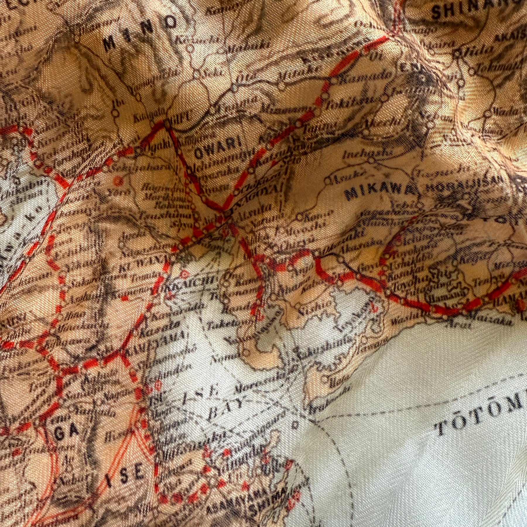 Close-up of a vintage map with red lines and black text on a beige background